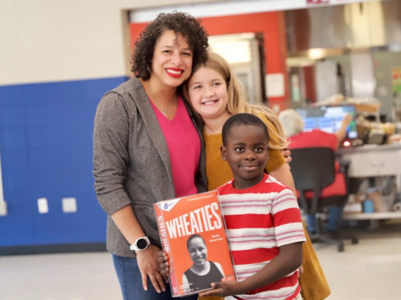 Dalla Emerson, food-service director for the Bowling Green Independent Schools, is congratulated by, from right, Wilondja Akili and Quinn Otto after General Mills honored her school-nutrition work by putting her photo on a Wheaties box. The students serve
