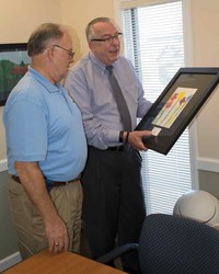 Armstrong (right) and KSBA President Allen Kennedy of Hancock County examine one of the prints in the room where the KSBA Board of Directors conducts many of its quarterly meetings. Armstrong said, “The opportunity to display the unique student art will allow our guests to view their work and hopefully support expanding the VSA program.”