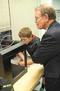 Lawrenceburg Mayor Sandy Goodlett watches as Anderson County Middle School eighth grader Aaron Chilton demonstrates a project he was creating on a 3D printer as part of one of the school’s STEM classrooms. Two other students, Hannah Whittaker and Camden Nicholson, led the tour, while a team from the school’s STLP program videotaped the event for part of its daily online newscast.
