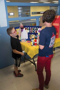 Projects were judged by several staff members, including the school’s reading interventionist Tammy Jo White. Third-grade student Keegan Miller, who chose Freckle Juice for his project, shows White the homemade freckle juice he made for the event.