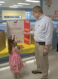 Montgomery County Superintendent Dr. Matt Thompson talks with kindergarten student Aubrey Fossier about her book choice, The Story of Ferdinand. Thompson told her that was his favorite book. Fossier said it took her about three hours to do her project and that “reading is my favorite thing in the world.”