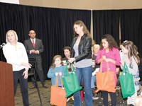 Community Education Director Debi Jordan recognizes four Warren County students for sweeping the event’s arts program, in which they created designs for a local attraction’s gift shop. From left, the students are Addison Rosado, a Jody Richards Elementary School first-grader; Liz DeMarse, a Drakes Creek Middle School eighth-grader; Harley Wilson, a Lost River Elementary School sixth-grader; and Hayden Wolf, a North Warren Elementary School third-grader. A fifth winner, Bosco Tuyisenge, a Henry F. Moss Middle School eighth-grader, was unable to attend.