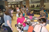 Spencer Elementary School secretary Judy Henry helps a mother complete enrollment paperwork for the 2016-17 year. Principals and other staff from both district elementary schools and its preschool program fielded questions from parents on topics like supplies and daily schedules.