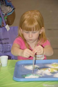 Future Spencer County student Haylie was one of many who lined up to experiment with mixing water and common chemicals at this booth operated by the Kentucky Science Center. Snacks, face painting and time in a pair of inflatable “castles” held the attention of children, giving parents extra time to talk with school and early childhood agency staff members.