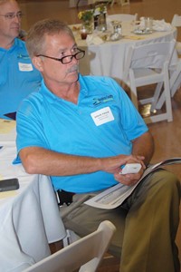 Hopkins County Board of Education member Steve Faulk votes at the Second Region meeting in Webster County during an instant poll on issues projected for the 2017 General Assembly, including the retirement system for classified employees and mandatory financial literacy courses for students. Participants also were polled about KSBA’s new legal training service for board members.