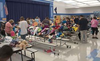 Parents and children look through tables loaded with donated clothing. Participants received a bag they could fill up during the fair. According to David Eddy, Trimble County’s family resource coordinator,  almost 500 people attended this year’s event. 