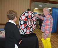 A conference attendee spins the wheel at the Wehr Constructors booth.