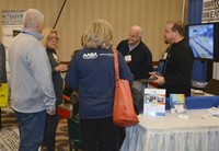 Conference attendees talk to representatives of Toadvine Enterprises during the Annual Conference Tr