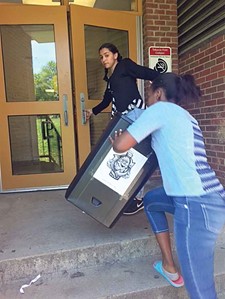 Students at Morton Middle School return a recycling bin to a classroom after emptying it into an outside receptacle.