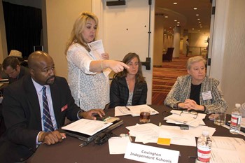 Jennifer Steidel-Jones, a novice reduction coach for the Kentucky Department of Education (and Silver Grove Independent school board member) assists a delegation from Covington Independent in sifting through district data in KDE’s Open House portal. From 