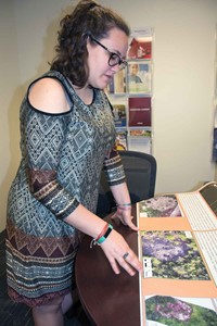 Rebekah Vermillion looks over a poster with aerial drone photos of an archeological site in Mexico.