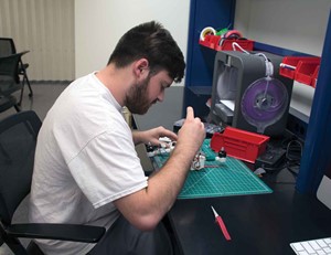 Garrett Jones works to construct a drone using parts he made from a 3-D printer.