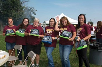 A group from Elkhorn Middle School poses with their giveaway Franklin County Schools lunch containers at the district’s opening day cookout.