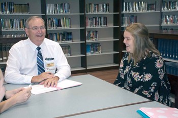 School safety assessment team member Mike Blevins, a retired Boone County Schools administrator, shares a lighter moment with a group of Nelson County High school students he is interviewing, including Katye Berry.