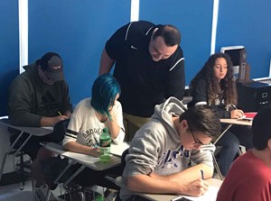 Math teacher Dustin Adams helps out a student in one of his classes at Paintsville High School, from which he graduated in 2012. (Photo courtesy of Paintsville Independent Schools)