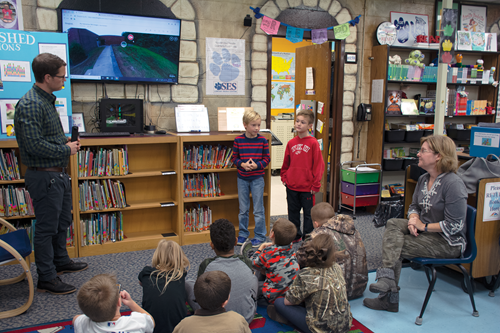 Students in STLP learn how to present their projects. Simpson Elementary students use pictures taken with 360-degree cameras in their presentation about the water problems as their teachers Sam Northern and Triscilla Harding look on. 