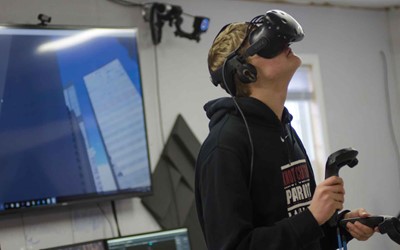 Knott Central student Colbie Napier tests the new virtual reality program at the Kentucky Valley Educational Co-op. What he is seeing through the headset is displayed on the screen behind him. KVEC is adding a VR program as another option for students.