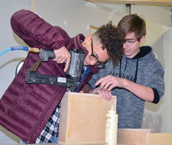 Raymon Rogers-Casando, left, and Logan Robinson work on a wood-working project during carpentry class at the Home Builders Association of Northern Kentucky.