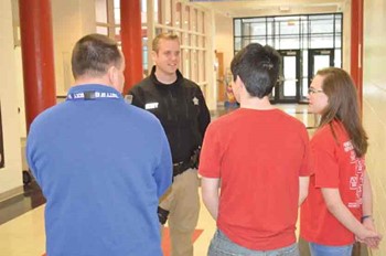 On his first day as a school resource officer at Sharp Middle School, Pendleton County Sheriff’s Deputy Aaron Adams talks with, left to right, Principal David Sledd and students. (Photo courtesy of Keith Smith, Falmouth Outlook)