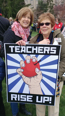 Harrison County school board member Mary June Brunker, right, and Harrison County teacher Helen Jones at the April 2 Capitol rally. Brunker said the poster was made by a Marshall County art teacher.