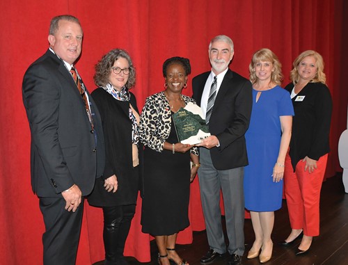 KSBA President David Webster presents the PEAK Award to Newport Independent school board Chair Ramona Malone, who is also on KSBA’s Board of Directors, during a ceremony May 7 at Newport High School. 