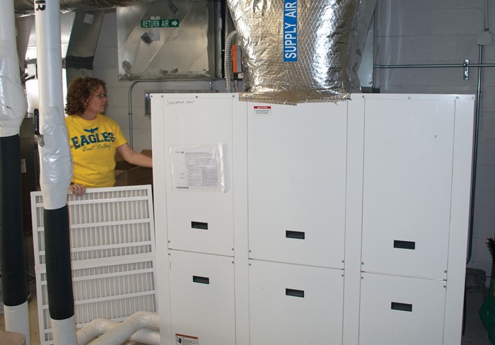 East Valley Elementary custodian Mary Brown changes a filter in the school’s new HVAC system. 