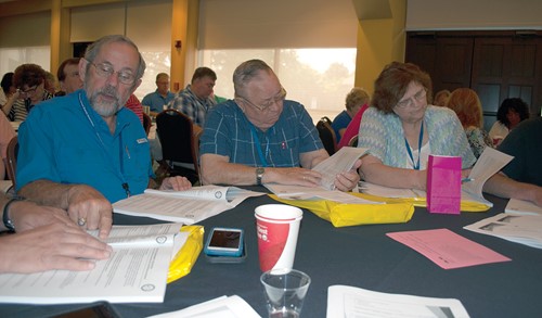 (l-r) Laurel County school board member Charles “Bud” Stuber, Berea Independent board member Will Bondurant and Martin County board Chair Kathleen Price look over the state budget bill during the clinic session.