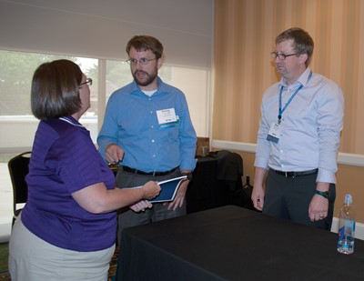 Campbell County school board member Kimber Fender talks with Perry Papka of the Prichard Committee for Academic Excellence (center) and Matt Bubness of the Government Finance Officers Association after their session during SLI.