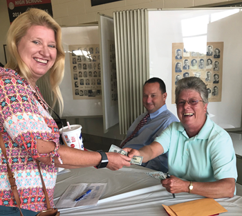 Pendleton County teacher Michelle Lustenberg (left) receives $100 from Kay Mudd, Pendleton County Education Foundation director, as David Sledd, principal of Phillip Sharp Middle School, looks on.
