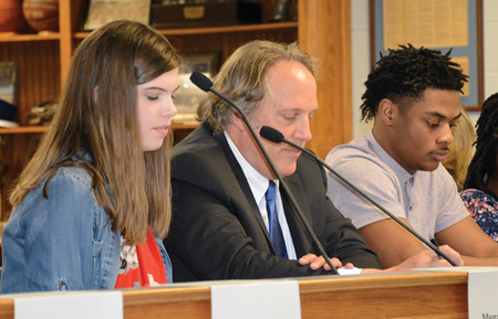 Paducah Independent school board Chairman Carl LeBuhn (center) is flanked by Paducah Tilghman High School seniors Megan Davis and Keyshun Curry during the district’s March meeting.