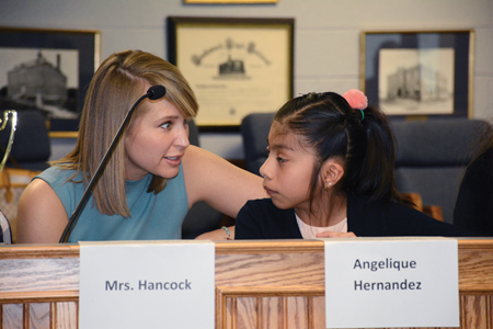 Paducah Independent school board member Mary Hancock talks to fifth-grade student Angelique Hernandez during the district’s March meeting. “I just realy wanted to meet the people here,” Hernandez said of why she wanted to participate in the program.